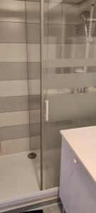 a shower with a glass door in a bathroom at T2 Cosy avec jardin et parking gratuit à Troyes in Troyes