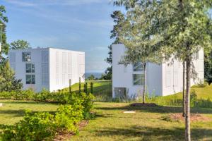 a white building on a hill next to a yard at Apartment B 1 "Pine Hill Resort" Family mit eigenem Fahrradabteil und Südterrasse im "Pine Hill Resort" in Zirchow