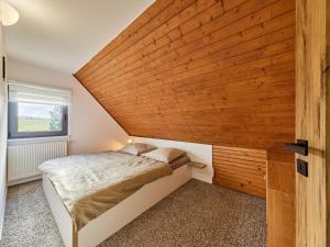 ein kleines Schlafzimmer mit einer Holzwand in der Unterkunft Holiday Home Holiday Hill 58 by Interhome in Lauterwasser