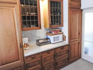 a kitchen with wooden cabinets and a microwave on a counter at Holiday Home Sunny Day by Interhome in Balatonmáriafürdő +20 photos