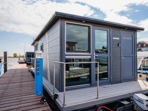 une petite maison sur un bateau à quai dans l'établissement Holiday Home De Meerparel-1 by Interhome, à Uitgeest