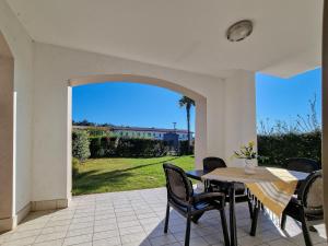 patio con mesa, sillas y vistas en Villaggio Evanike, en Bibione