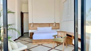 a bedroom with a bed and a desk and a chair at Villa Daya Canggu - 5 Mins to Beach, Rooftop Cinema and Private Cook in Canggu +13 photos