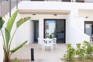 a white house with a white table and chairs at La Herrada Home in Los Montesinos