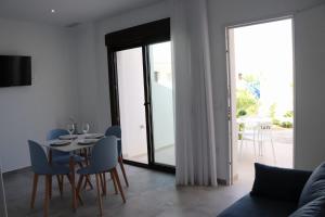a living room with a table and chairs and a glass door at La Herrada Home in Los Montesinos