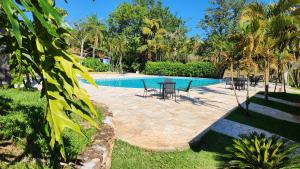 a swimming pool with a table and chairs next to it at Quinta das Águas by Summit Hotels in Itapira