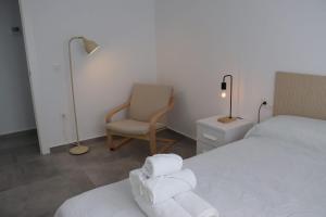 a bedroom with a bed and a chair and a lamp at La Herrada Home in Los Montesinos +57 photos