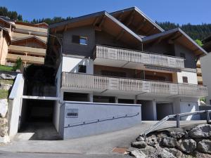 a large apartment building with a parking lot at Charmant appartement central avec WIFI - FR-1-693-36 in Châtel