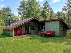 ein Haus mit roten Stühlen und einer Terrasse in der Unterkunft Holiday Home Elfrieda - 1-6km from the sea by Interhome in Læsø