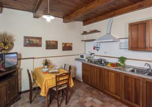 eine Küche mit Tisch und eine Küche mit Spüle in der Unterkunft Freistehendes Agriturismo in der Toskana für zwei Personen mit großem gemeinschaftlich genutzten Gar in Pratovecchio