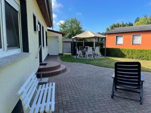 un patio avec des chaises et une table et un bâtiment dans l'établissement Klosterwald, à Dargun