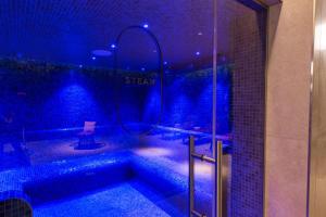 ein Badezimmer mit einer Dusche mit blauen Lichtern in der Unterkunft Skyline Apartment With Thermal Spa in Manchester