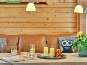 einen Tisch mit Kerzen und ein Ledersofa in der Unterkunft Holiday Home Jorina - 700m to the fjord by Interhome in Ringkøbing