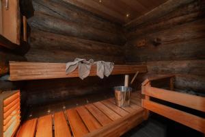 a wooden cabin with a bench and a bucket in it at Villa Talvikolo - Spacious 2BR Cabin with Sauna in Ruka