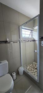 a bathroom with a toilet and a glass shower at Your Happy Holiday Place in La Mercy +18 photos
