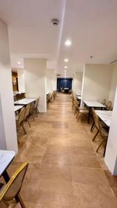 a row of tables and chairs in a restaurant at فندق الطلائع الذهبي in Az Zahrāʼ