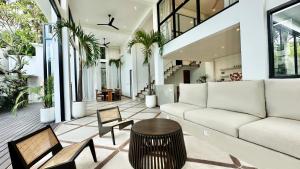 a living room with a couch and a table at Villa Daya Canggu - 5 Mins to Beach, Rooftop Cinema and Private Cook in Canggu