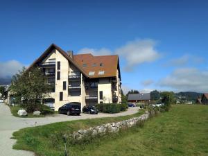 a house with two cars parked in front of it at Appartement cosy 4 pers avec balcon sud, proche centre et pistes – Autrans-Méaudre en Vercors - FR-1-737-9 in Méaudre