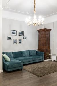 a living room with a blue couch and a chandelier at Romari Братів Рогатинців 32 in Lviv