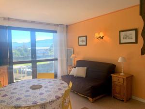 - une chambre avec une table, un canapé et une fenêtre dans l'établissement Appartement à Autrans, balcon sud, 4 pers, animaux admis, parking à 500m du centre - FR-1-737-38, à Autrans