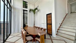 a dining room with a wooden table and chairs at Villa Daya Canggu - 5 Mins to Beach, Rooftop Cinema and Private Cook in Canggu