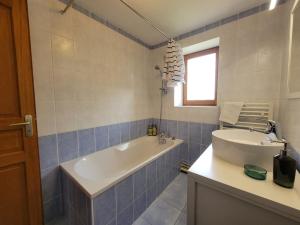 a bathroom with a tub and a sink at Maison Céline - Jardin clos et Parking Privé Gratuit in Crevant-Laveine +26 photos