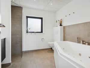 une salle de bain blanche avec une baignoire et des toilettes dans l'établissement Holiday Home Malfred - 500m from the sea by Interhome, à Odder