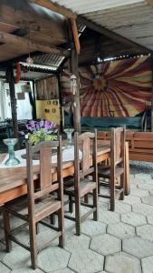 a wooden table and chairs with flowers on it at Chalés Recanto da Aldeia in Itanhaém +36 photos