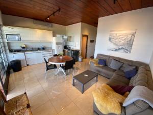 a living room with a couch and a table and a kitchen at Villa Querência na Represa Avaré in Avaré