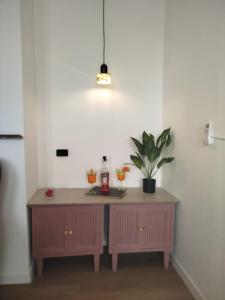 ein Raum mit zwei Tischen, auf denen Getränke und eine Topfpflanze stehen in der Unterkunft HERITAGE HOUSE City Center -ENTIRE APARTMENT- in Pescara