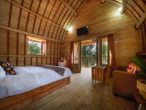 a bedroom with a bed in a room with wooden walls at Wisnu Lumbung Uluwatu in Uluwatu +56 photos
