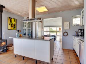 a kitchen with a white island in the middle at Holiday Home Ljubinko - 50m from the sea by Interhome in Læsø