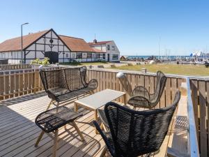 four chairs and a table on a deck with a lighthouse at Holiday Home Ljubinko - 50m from the sea by Interhome in Læsø