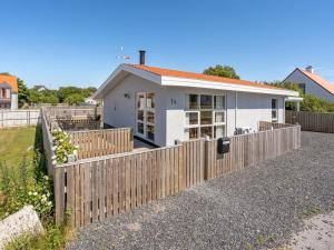 a house with a wooden fence in front of it at Holiday Home Ljubinko - 50m from the sea by Interhome in Læsø