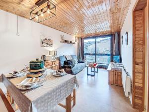 a living room with a table and a couch at Apartment Pegase Phenix-74 by Interhome in Le Corbier