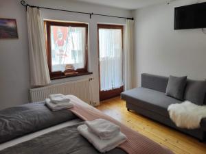 a living room with a couch and two windows at Zum Schneider in Finkenberg