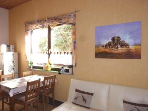 une salle à manger avec une table et une photo d'éléphant dans l'établissement Blick In Die Natur, à Ilmenau