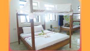 ein Schlafzimmer mit einem Himmelbett mit weißen Laken in der Unterkunft CAAA Youth Hostel 