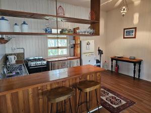 谭伯连山Main St Heritage Charm & Walk to Restaurants的厨房设有木酒吧,里面设有凳子