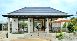 春蓬BLU-LIB Hotel的一座带黑色屋顶和庭院的房子