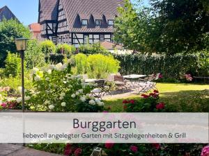 a garden with flowers and a building in the background at HINTERBURG SCHLITZ - Großes Burgen-Apartment mit 4 Schlafzimmern & 2 Bädern - ideal für Familien und Gruppen, inklusive kostenloser Parkplätze, Aufzug und Garten in Schlitz +48 photos