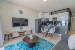 a living room with a couch and a table at Serenity Suite Bellamare in Summerstrand