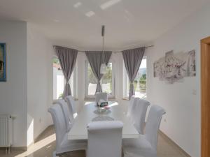 a white dining room with a white table and white chairs at Holiday Home Ana by Interhome in Donji Proložac