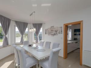 a white dining room with a white table and chairs at Holiday Home Ana by Interhome in Donji Proložac +31 photos