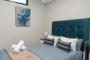 a bedroom with a bed with a green headboard at Serenity Suite Bellamare in Summerstrand +35 photos