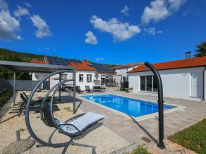 a swimming pool with a swing and a house at Holiday Home Ana by Interhome in Donji Proložac