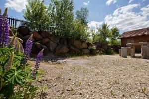 einen Garten mit einem Steinzaun und lila Blumen in der Unterkunft Ferienwohnung für 4 Personen  2 Kinder ca 85 m in Waldmünchen, Bayern Bayerischer Wald in Waldmünchen