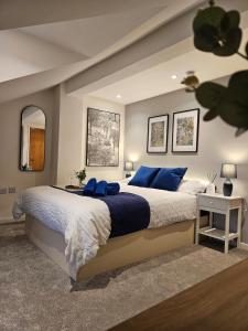 a bedroom with a large bed with blue pillows at Spacious 3-Bedroom Apartment with Private Parking & Wi-Fi in Hull