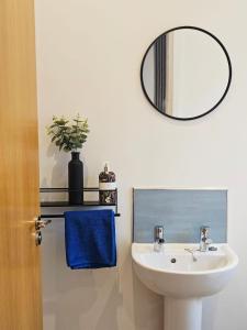 a bathroom with a white sink and a mirror at Spacious 3-Bedroom Apartment with Private Parking & Wi-Fi in Hull
