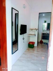 ein Wohnzimmer mit einem TV und einem Spiegel in der Unterkunft 204 Casa de Rany in Daro